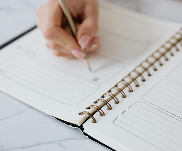 A calendar and a journal on a desk suggesting daily routine.